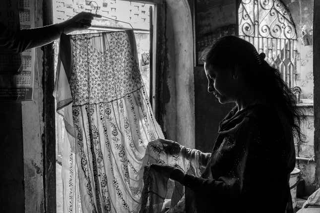 Zeenat inspects a dress made out of real gold and silver wires, recalling the golden memories of the past. Deorhi Agha Meer, Chandi Khana, Old Lucknow, Uttar Pradesh.