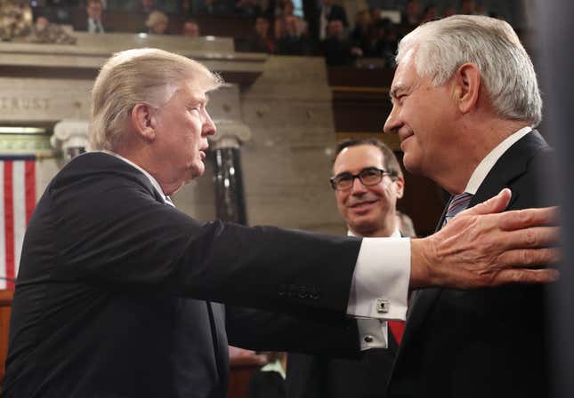 Trump greets Steve Mnuchin (C) and Rex Tillerson (R) after delivering his first address to a joint session of Congress.