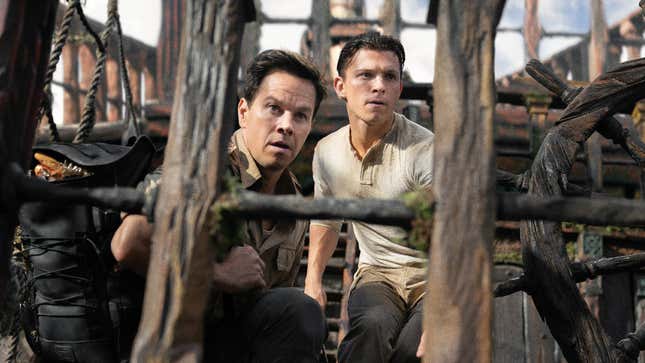 Mark Wahlberg as Sully and Tom Holland as Drake stand on a pirate ship and look surprised in the Uncharted movie.