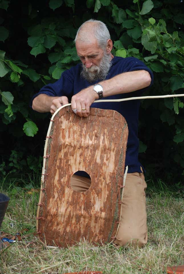 An experimental archaeologist reconstructing the bark shield.