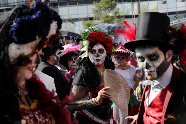 Participants painted their faces to look like skulls. The woman at center is dressed as La Catrina, the dapper skeleton from the work of Mexican folk artist Jose Guadalupe Posada.