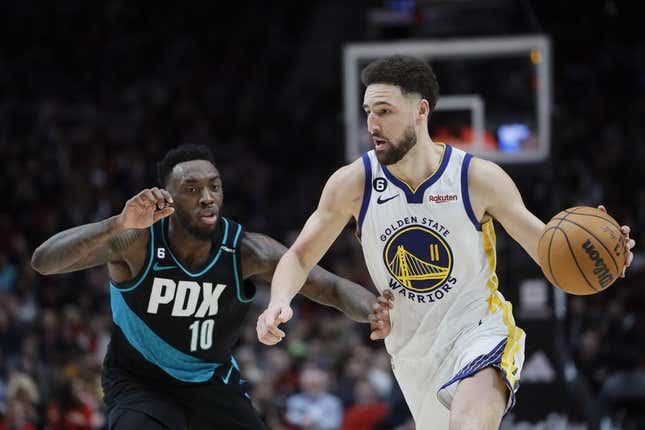 Feb 8, 2023; Portland, Oregon, USA; Golden State Warriors shooting guard Klay Thompson (11) dribbles the ball as Portland Trail Blazers small forward Nassir Little (10)  defends during the second half at Moda Center.