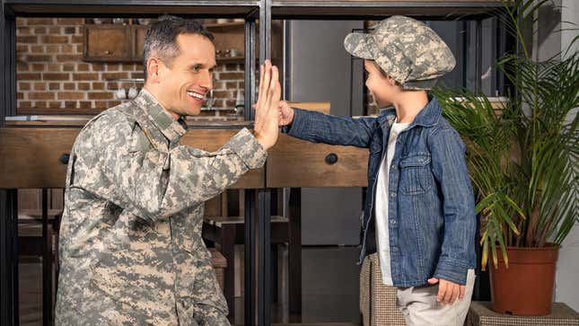 A solider high fives with a young, impressionable mind.