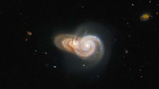 Distant orange and whitish galaxies overlap one another in space.