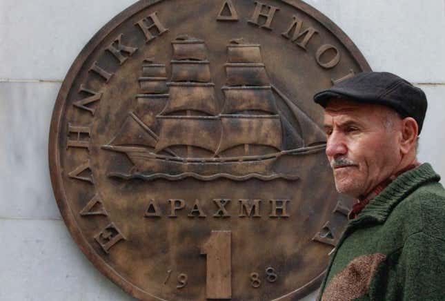 A man passes in front of a huge replica of a one drachma coin in Athens in 2011.