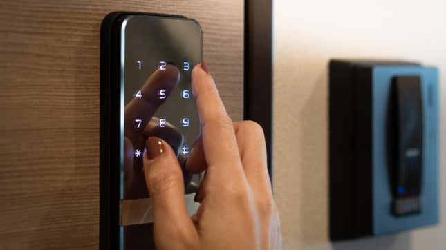 woman entering a code on a touchscreen keypad entry device