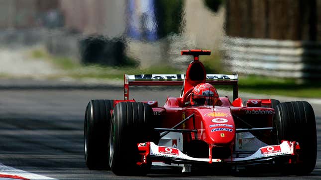 A photo of Michael Schumacher driving a red Ferrari F2004 F1 car. 