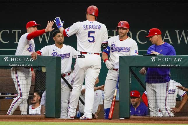 Apr 10, 2023; Arlington, Texas, USA; Texas Rangers shortstop Corey Seager (5) is greeted at the dugout after hitting a solo home run during the first inning against the Kansas City Royals at Globe Life Field.