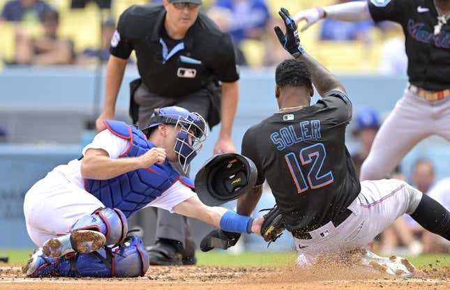 Aug 19, 2023; Los Angeles, California, USA;  Los Angeles Dodgers catcher Austin Barnes (15) tags Miami Marlins designated hitter Jorge Soler (12) out at home on a throw by Los Angeles Dodgers right fielder David Peralta (6) in the third inning at Dodger Stadium.
