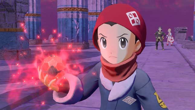 A Pokémon trainer is seen holding a glowing red Pokéball, Irida and Kamado are seen behind him, watching in shock at something off camera.