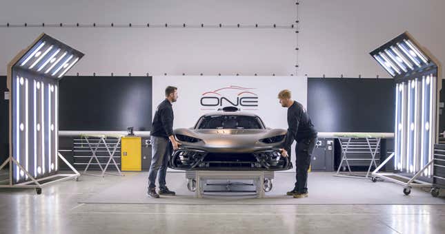 Two men fit the bumper to a $3 million hypercar.