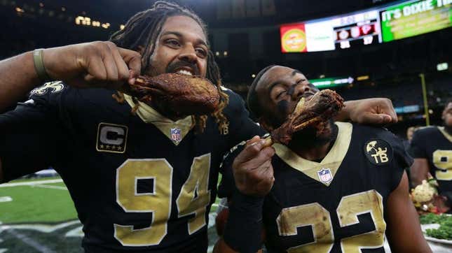 NFL players eating turkey legs on field