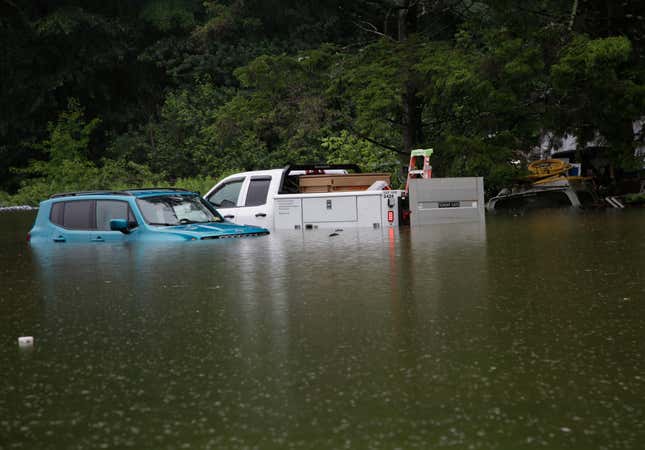 Floodwaters rise in Bridgewater, Vt., on Monday, July 10, 2023, submerging parked vehicles and threatening homes near the Ottauquechee River.