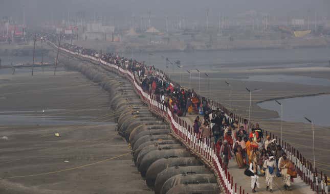 Pilgrims walk on a pontoon bridge to offer prayers at the Sangam.