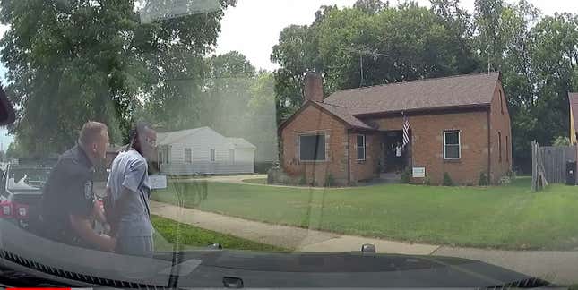 This Aug. 1, 2021 image from video provided by the Wyoming, Mich., Police Department shows a Wyoming Officer handcuffing real estate agent Eric Brown outside a home he was showing to a potential buyer in Wyoming, Mich. Police handcuffed the realtor, his client and that man’s 15-year-old son this month after a neighbor wrongly reported the three Black people were breaking into a home.