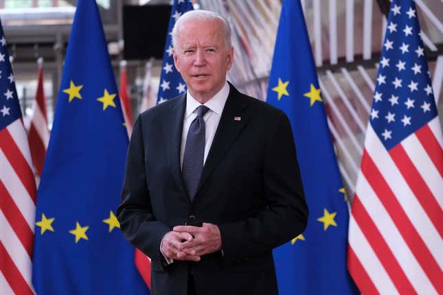 Joe Biden standing in front of American and European Union flags