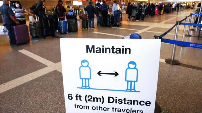 Travelers wait in line to check in for a flight at the Tom Bradley International Terminal at Los Angeles International Airport (LAX) amid a COVID-19 surge in Southern California on December 22, 2020 in Los Angeles, California. 