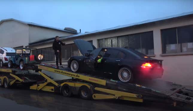 Black sedan struggles to stay running on German car transporter truck.