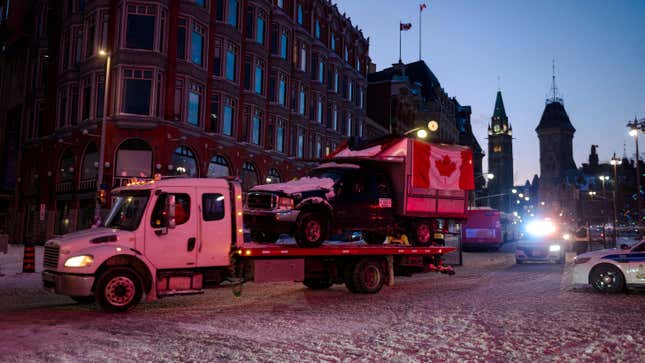 A flatbed removes a truck from the convoy after police cleared Wellington Street, previously occupied by the Freedom Convoy in Ottawa, on February 19, 2022. - Ottawa Police Services barricaded Wellington St. around Parliament Hill, clearing up the trucks and the camps that had been in Ottawa since January 28, 2022. Police in Canada deployed to dislodge the final truckers and protesters from downtown Ottawa, in a mostly peaceful operation aimed at bringing an end to three weeks of demonstrations over Covid-19 health rules. (Photo by Andrej Ivanov / AFP)