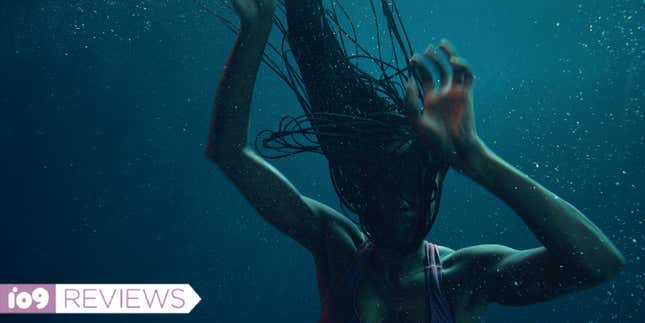 A woman with long hair in the dark underwater