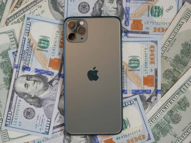 An iPhone on top of a pile of money.