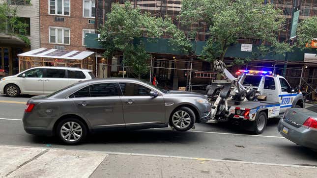 A photo of a car getting towed by police. The government of Latvia is seizing cars and donating them to Ukraine.
