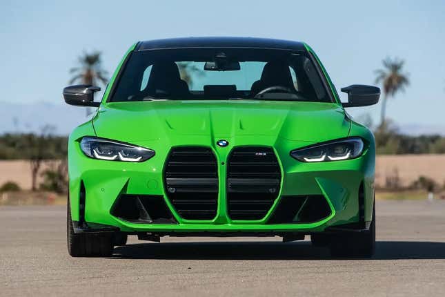 A bright green BMW M3 is parked on tarmac.
