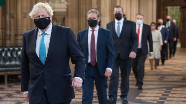Prime Minister Boris Johnson (L) and Labour leader Sir Keir Starmer (2nd L) walk through the Central Lobby after listening to the Queen’s Speech during the State Opening of Parliament in the House of Lords at the Palace of Westminster on May 11, 2021 in London, England.