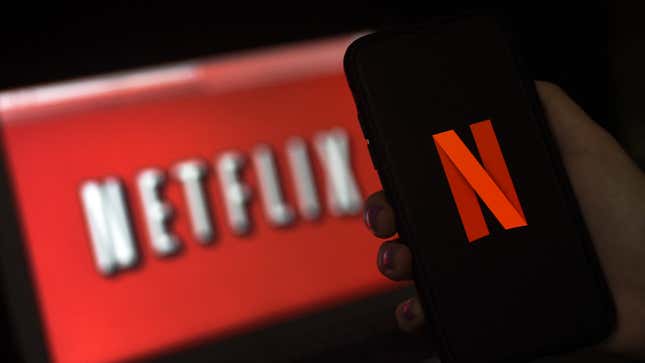 The Netflix red "N" on a phone is shown with the company's older white on red logo in background.