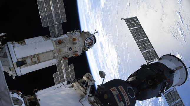 El módulo Nauka (izquierda) acoplado a la EEI, con una nave espacial Soyuz (derecha) cerca.