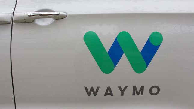 A photo of a Waymo logo on a car door.
