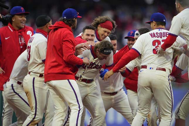 Apr 8, 2023; Philadelphia, Pennsylvania, USA; Philadelphia Phillies second baseman Bryson Stott (5) is mobbed by his teammates to congratulate him for getting the winning hit in the ninth inning against the Cincinnati Reds at Citizens Bank Park.