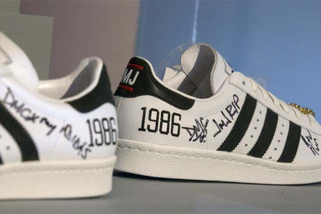 A pair of black and white Adidas sneakers, signed by the members of Run D.M.C.