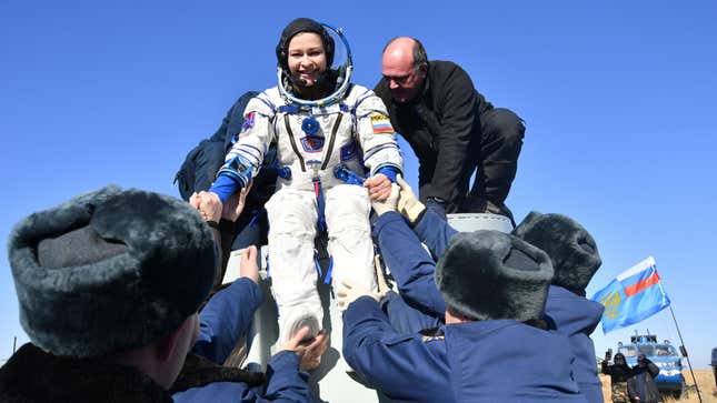 Russian space agency rescue team members help actress Yulia Peresild out from the capsule shortly after the landing of the Russian Soyuz MS-18 space capsule.
