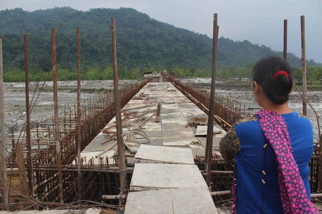 A Idu lady looks at the unfinished Dipu Nallah bridge, with Tezu on the other side.