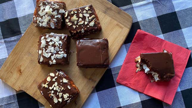 Snack cakes sitting on a wooden cutting board, with one bitten cake on a red napkin