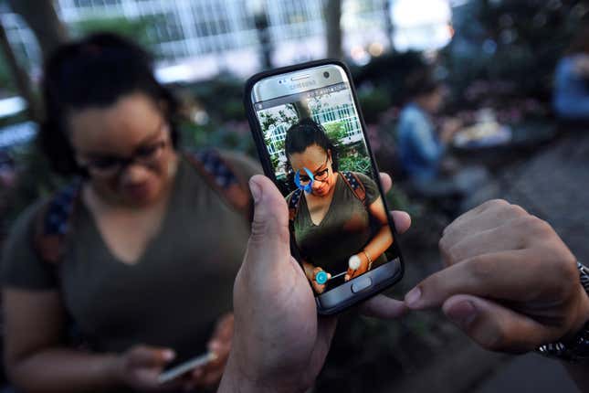 A Pokemon appears on the screen next to a woman in the augmented reality mobile game “Pokemon Go” in Bryant Park.