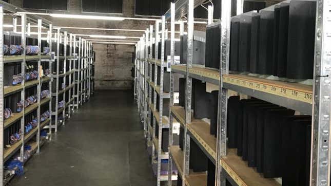 A warehouse hallway flanked on either side by stacks and stacks of PS4 Pros.