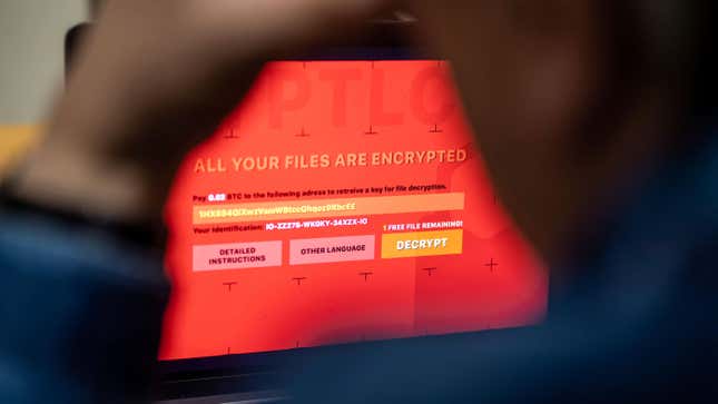 A man sits in front of a laptop infected with a fictitious encryption Trojan (ransomware).