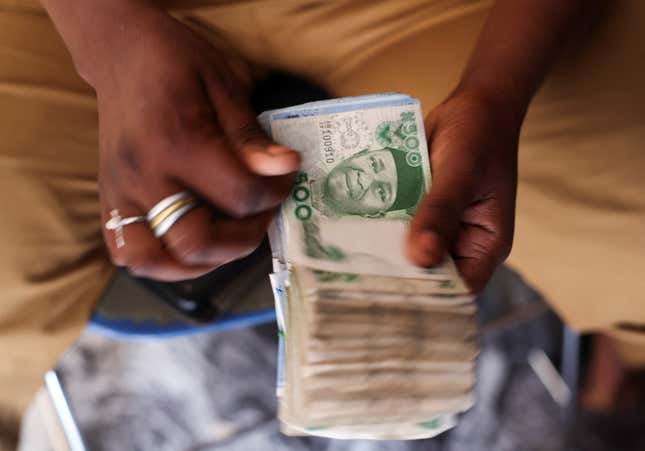 A man counts Nigerian naira notes in a market place as people struggle with the economic hardship and cashflow problems ahead of Nigeria's Presidential elections, in Yola, Nigeria, February 22, 2023.