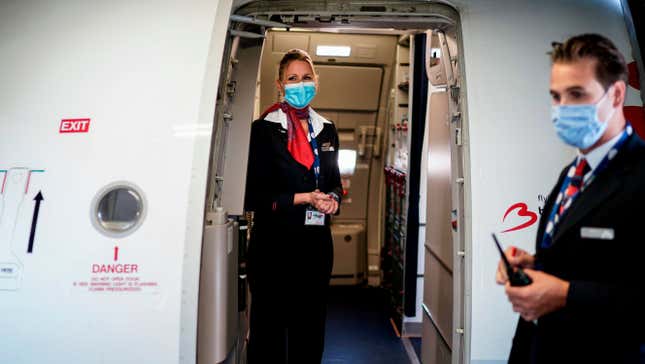 A cabin crew member wearing a protective face mask waits at the entrance of a Brussels Airlines plane, at Brussels Airport, in Zaventem, on June 15, 2020 as Brussels Airport reopens for travels within Europe and the Schengen zone, after a months-long closure aimed at stemming the spread of the COVID-19 pandemic, caused by the novel coronavirus. 