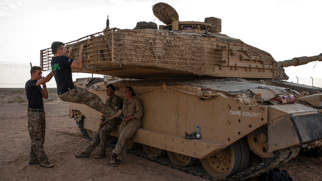 UK soldiers hang out with their tank.