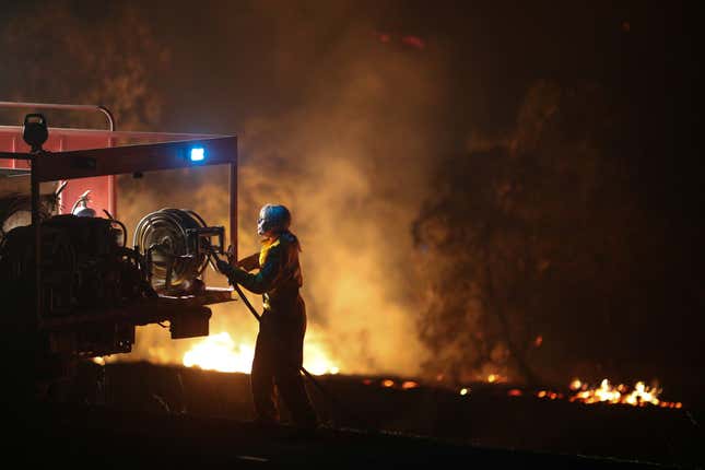 A firefighter works to extinguish flames after a bushfire burnt through the area in Bredbo, New South Wales, Australia earlier this month.