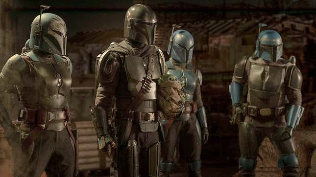 The Mandalorian and three other Mandaloriams stare at an unseen person.