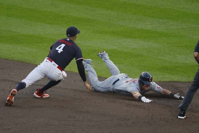 Aug 29, 2023; Minneapolis, Minnesota, USA; Cleveland Guardians first baseman Kole Calhoun (26) slides into second base for a double before Minnesota Twins shortstop Carlos Correa (4) can tag him in the third inning at Target Field.