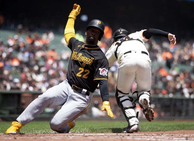 May 31, 2023; San Francisco, California, USA; Pittsburgh Pirates designated hitter Andrew McCutchen (22) slides safely home on a single by Rodolfo Castro as San Francisco Giants catcher Patrick Bailey (14) during the third inning at Oracle Park.