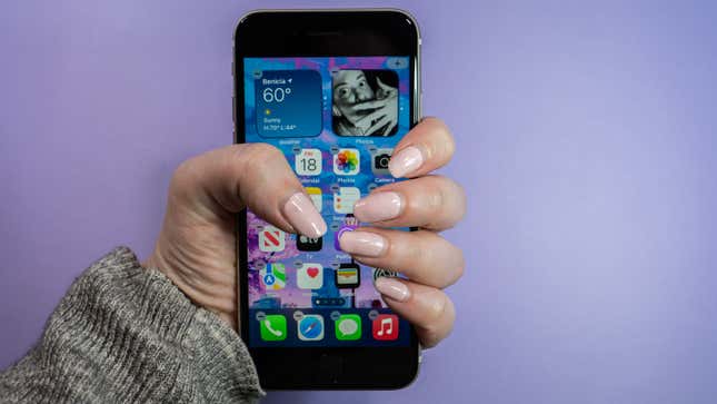 A photo of a person grasping the iPhone SE