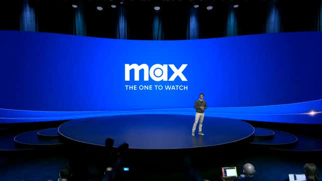 A person on a stage wit the Max the one to Watch Logo in the background.