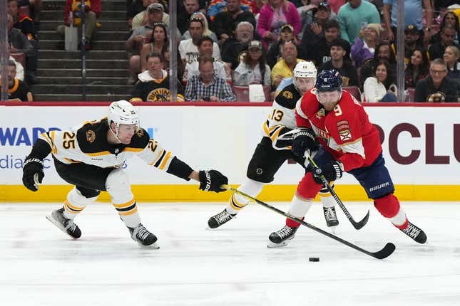 Apr 23, 2023; Sunrise, Florida, USA; Boston Bruins defenseman Brandon Carlo (25) reaches for the puck on Florida Panthers center Sam Bennett (9) during the second period of game four in the first round of the 2023 Stanley Cup Playoffs at FLA Live Arena.
