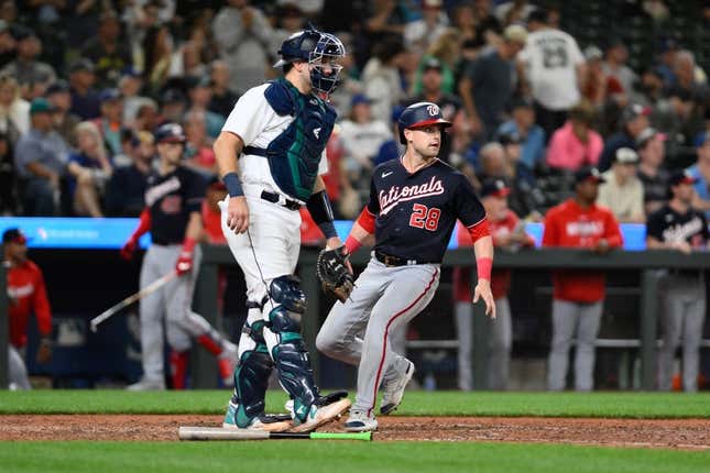Jun 27, 2023; Seattle, Washington, USA; Washington Nationals right fielder Lane Thomas (28) scores a run off a single hit by second baseman Luis Garcia (not pictured) during the eleventh inning at T-Mobile Park.